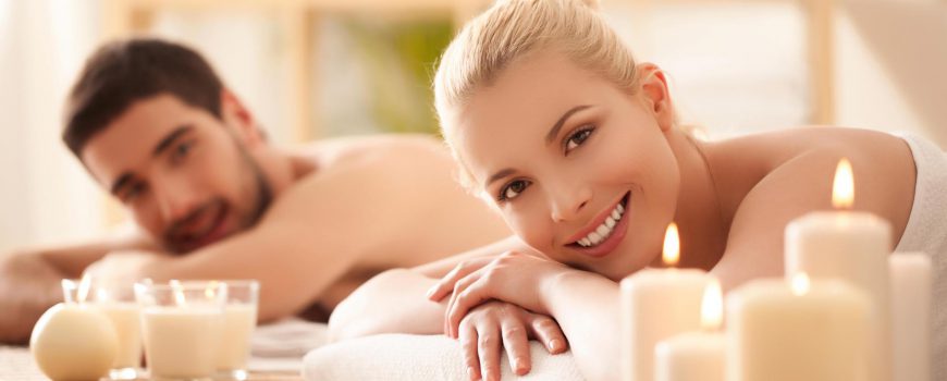 Young couple lying on the massage table and smiling.